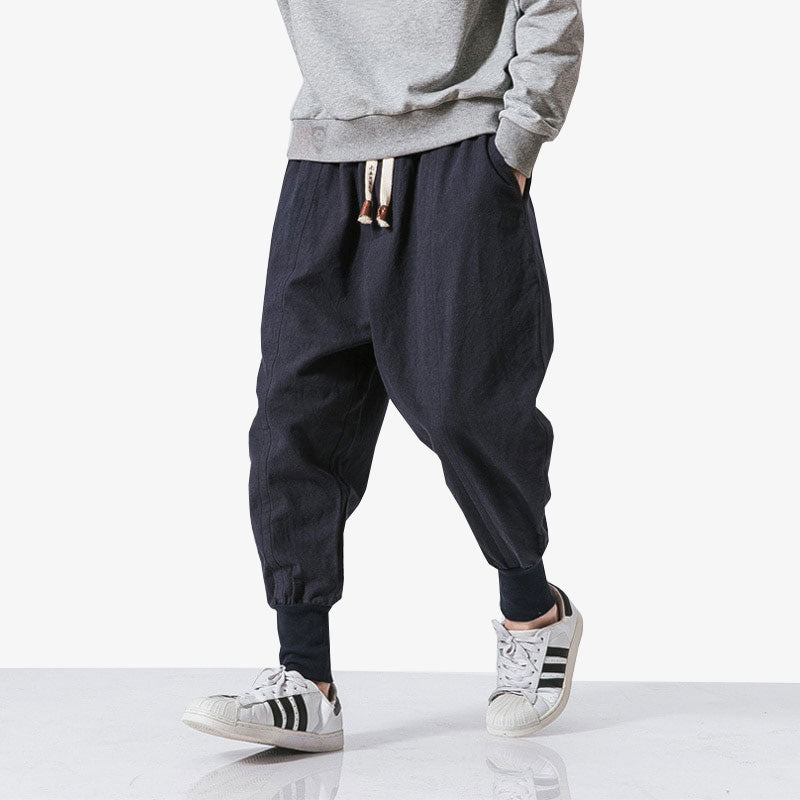 A Japanese man is dressed with Harajuku mens pants with a grey hoodie, and white sneakers for a casualt outfits