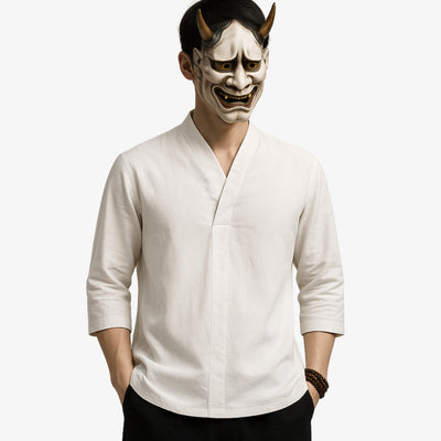 Person wearing a white Japan t-shirt white and a traditional Japanese mask with horns on a white background