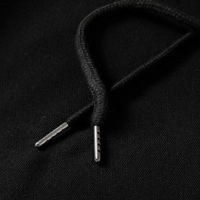 Close-up of japanese black shoelace with metal eyelets on a black background