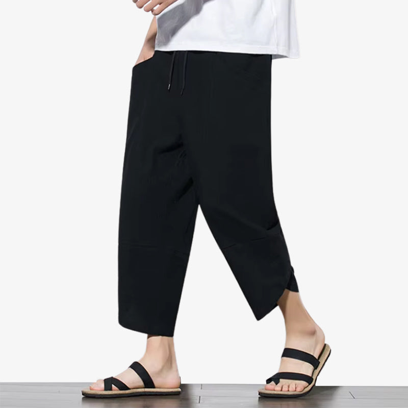 a man is dressed with a black Japanese casual pants designed with relaxed fits and subtle details inspired by everyday Japanese style.