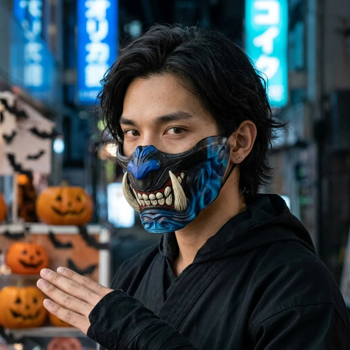 Black and blue oni half mask with ivory fangs worn at night for Halloween, blue Tokyo neon behind