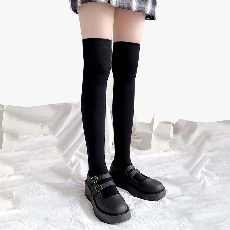 A girl is wearing a pair of Japanese  fashion long sockssocks with schoolgirl shoes and a checked skirt.