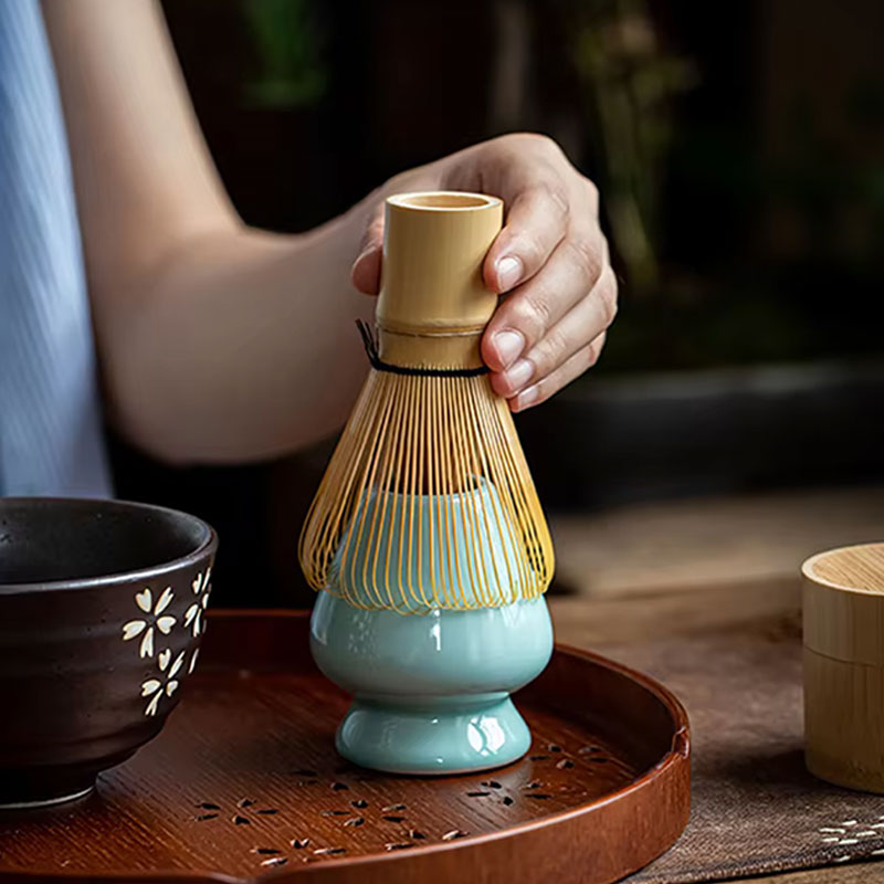 A women is holding in her hand a Japanese green tea whisk in bamboo, perfect for achieving the ideal texture in matcha tea