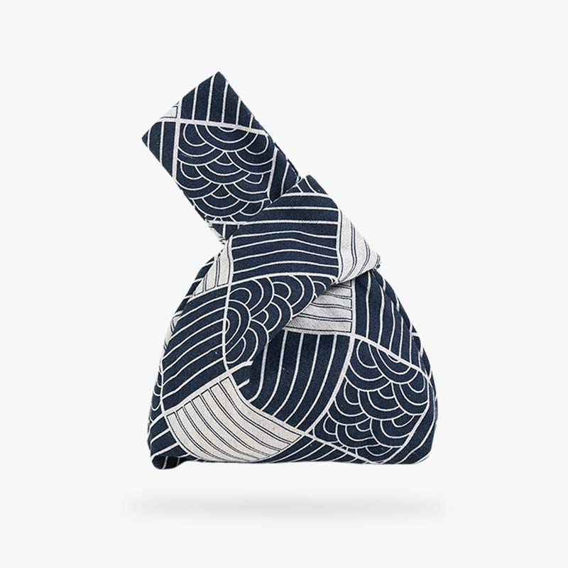 This traditional knot bag is a Japanese knot bag with seigaiha motifs. It's a blue and white cotton bag. Discover the sleek design of the japanese knot bag, a versatile accessory featuring a unique knot closure that blends both function and style