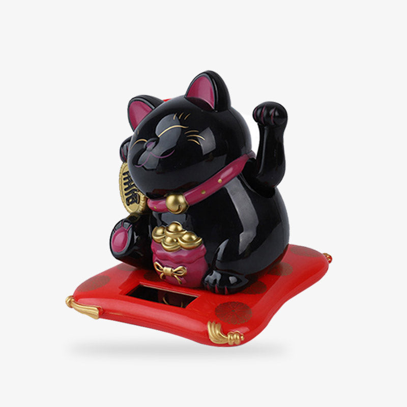 The Japanese lucky cat blac raises his left paw