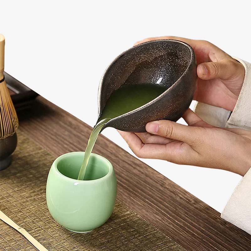 a women is serving tea in a white cup thanks to a Japanese matcha tea bowl crafted in ceramic, ideal for enhancing the tea-making ritual.