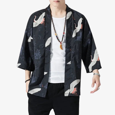 Person wearing a japanese men's kimono jacket​ with white crane designs on a white background