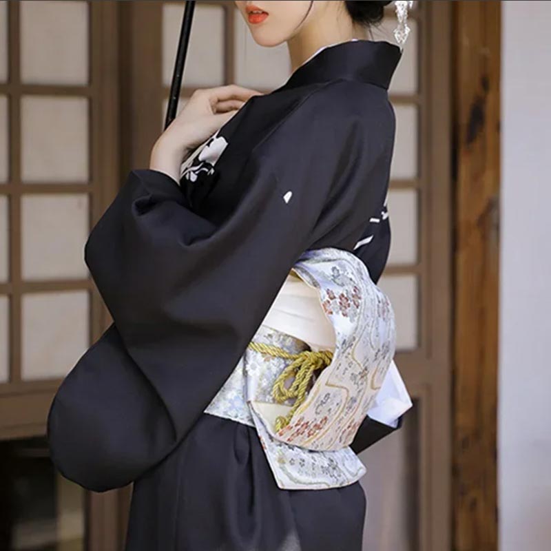 a women is dressed with japanese obi belt for sale and a traditional black kimono