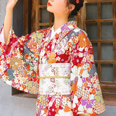 a woman is dressed with a japanese original kimono belt embroidered with japanese sakura patterns. The traditional kimono is red and the obi belt is white