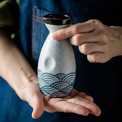 This is a Japanese sake bottle with a traditional seigaiha design, perfect for serving sake and adding an authentic touch to Japanese dining rituals. The japanese bottle is made with ceramic