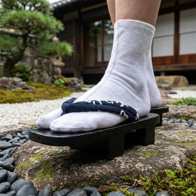Close-up of navy hanao strap with white characters on black geta