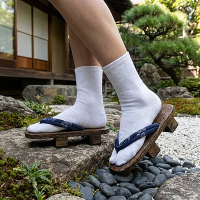 Japanese shoes woman wearing dark wood geta with navy hanao strap