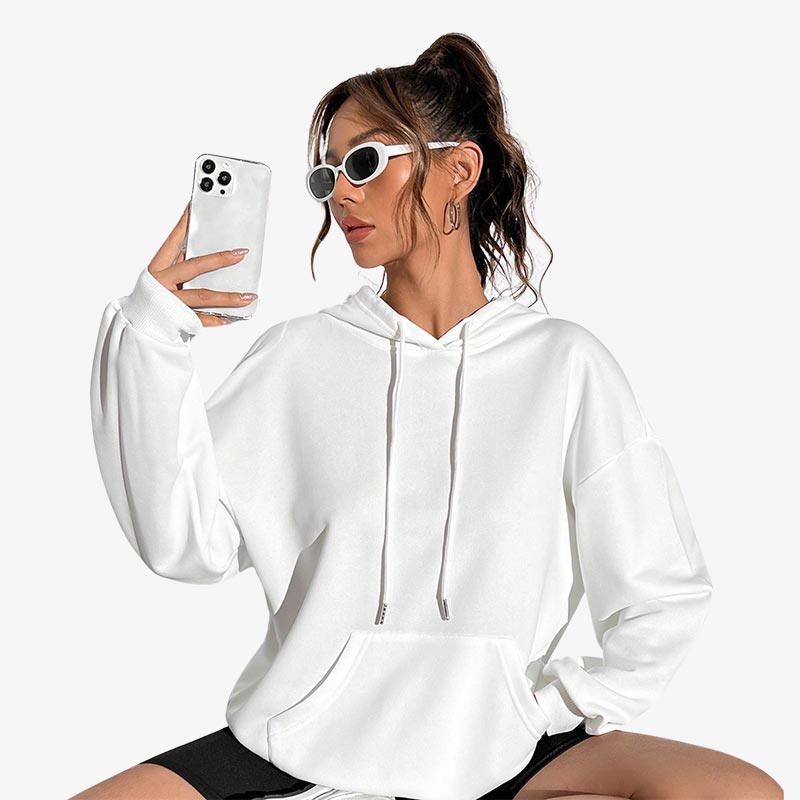 a girl is dressed with a Japanese street style hoodie made from durable fabric with minimalist white color, ideal for an urban and trendy look. She wears white sunglasses and she hold a white smartphone in her hand