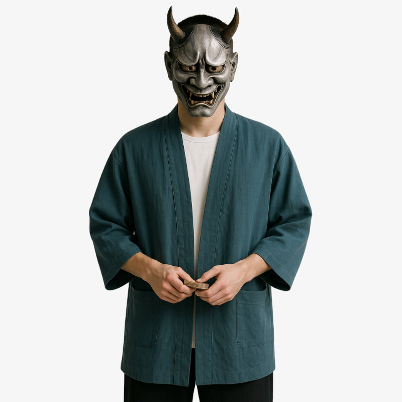 a man is dressed with Japanese style cardigan for men with elegant simplicity, blending tradition and streetwear. A grey handmade japanese hannya mask hides his face