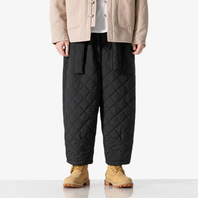 These Japanese-style cargo pants are black and fleecy. The fabric is synthetic for a streetwear style.