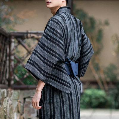 The Obi belt fastens the Japanese traditional kimono men outfit. The kimono dress for men is grey ciolor with stripes. The japanese belt Obi is blue