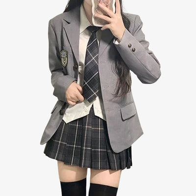 A girl is dressed with japanese uniform cosplay. Grey Japanese jacket, with a student plaid shirt, a white shirt, and a tie skirt