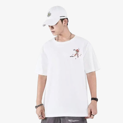 Person wearing a Japanese white embroidered shirt with floral design and a white cap on a white background