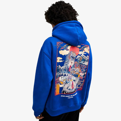 Person wearing a blue JPN hoodie with a colorful graphic on the back against a white background. The design represents a japanese komainu symbols