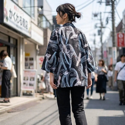 Woman seen from behind wearing a kimono style mens jacket in a Harajuku street