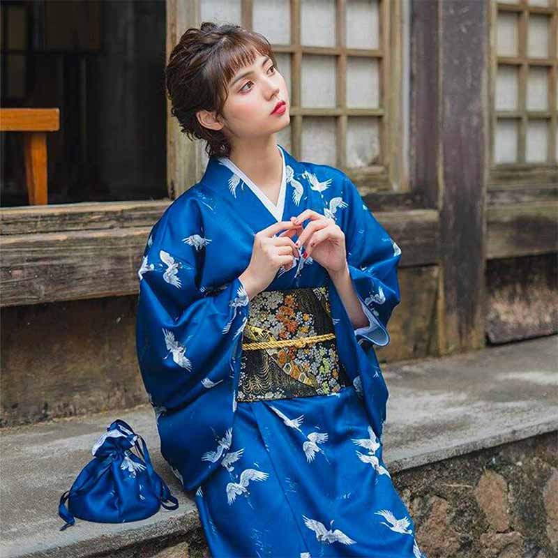 a woman is dressed with a kimono japan traditional and a obi belt embroidered with floral patterns