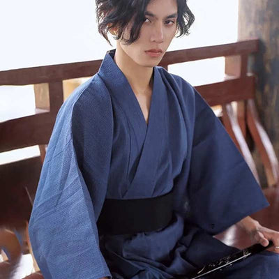 A Japanese man wears a kimono japanese traditional clothing and a black obi belt around his waist.