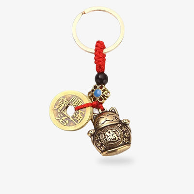 This maneki neko charms is a small Japanese brass cat statuette with a coin.