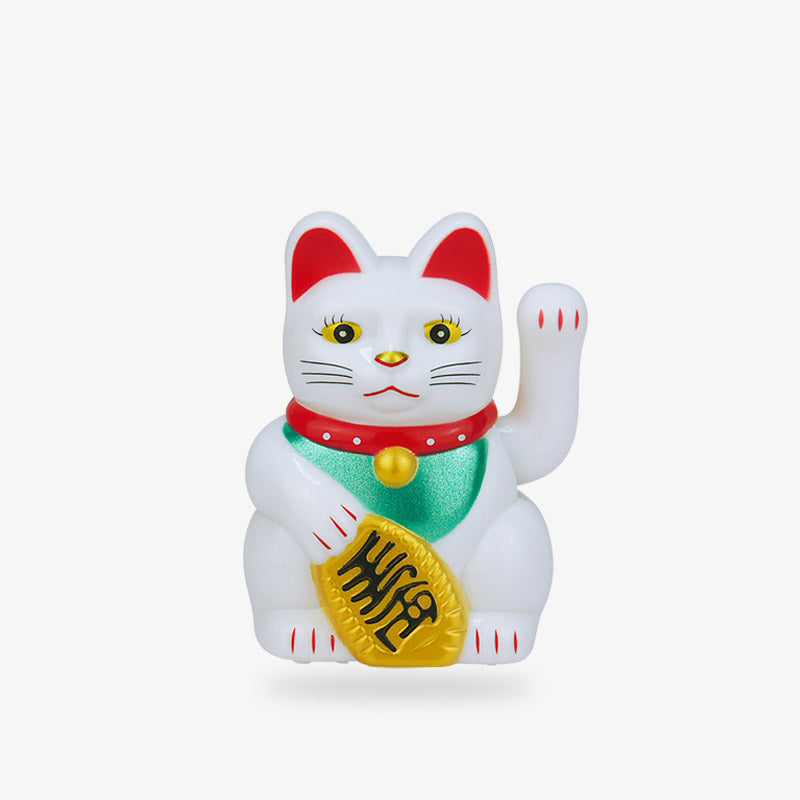 This maneki neko lucky cat is a Japanese lucky cat statuette. The white Japanese cat is holding a gold coin in its paw. Its second paw is raised. The maneki neko cat symbolizes luck and good fortune.