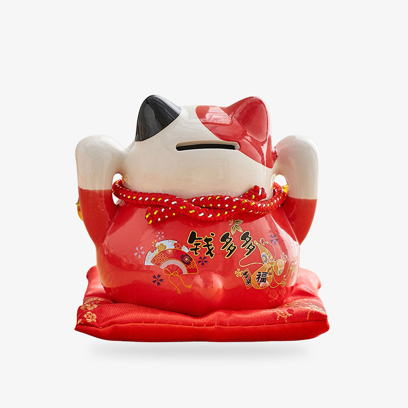 Maneki Neko piggy bank cat is red in colour with both paws raised. It's a lucky cat that brings good luck. It is used like a money box where you deposit coins.
