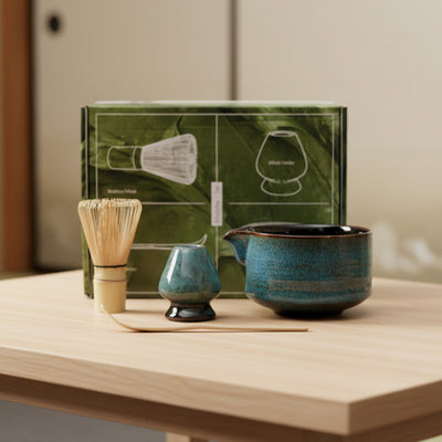 Matcha Tea-making set with a teapot, cups, and a box on a wooden surface.
