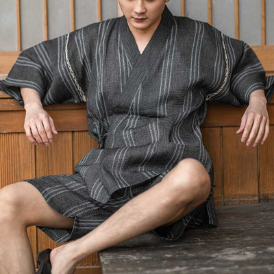 A man is dressed in a men Jinbei Japanese clothing made with linen and coton materia. Color of the summer Japanese kimono is grey