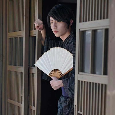 The mens dress kimono traditionalis still popular in Japan. This man is holding a white sensu fan.