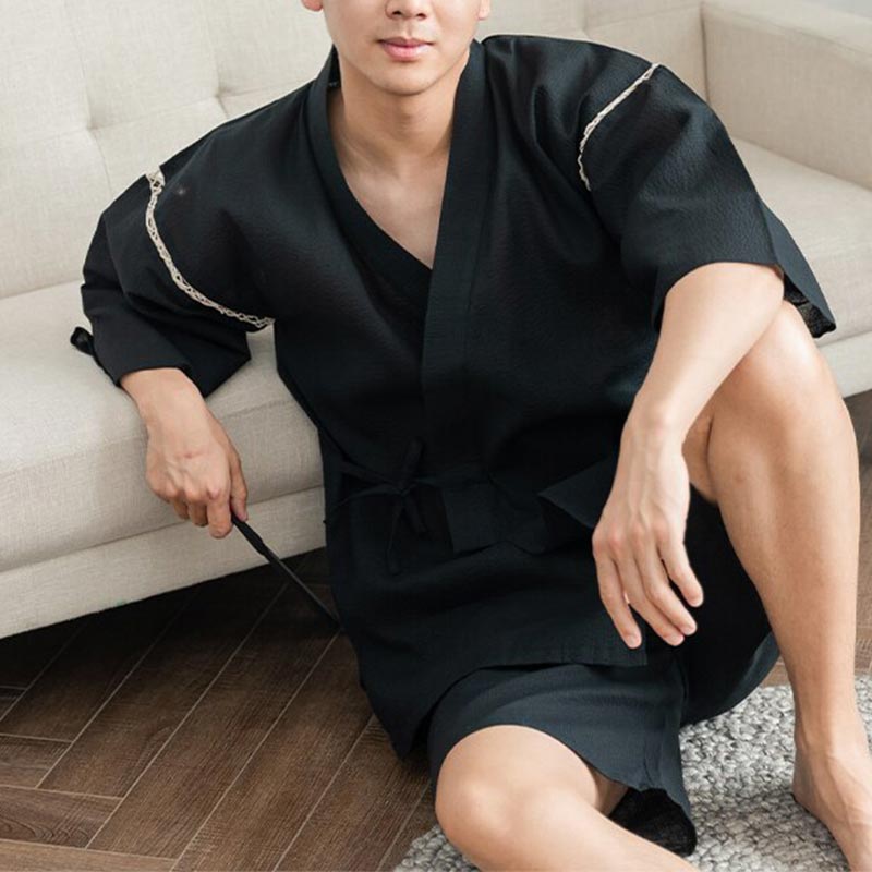 A Japanes is dressed in a mens Japanese Jinbei. This is a traditional Japanese garment worn with shorts and a kimono top.