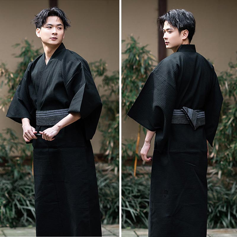 The same person is dressed in a mens kimono black. The yukata is tied with a grey Obi belt.
