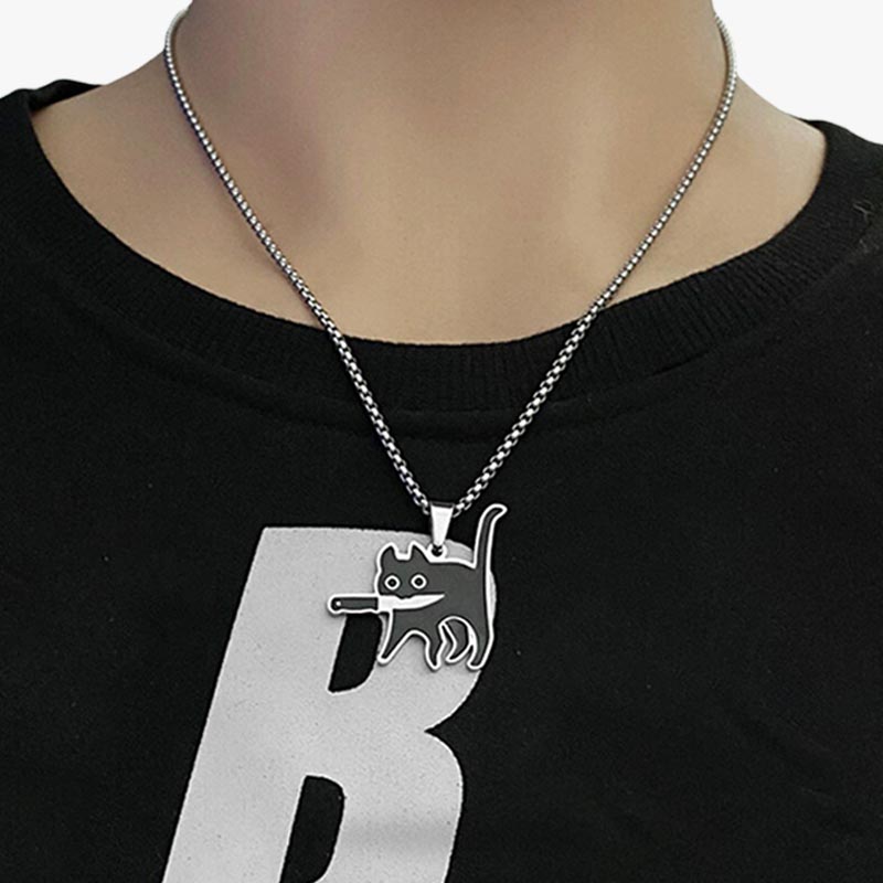 A woman wearing a necklace kawaii animal necklace with a black jumper and a silver chain