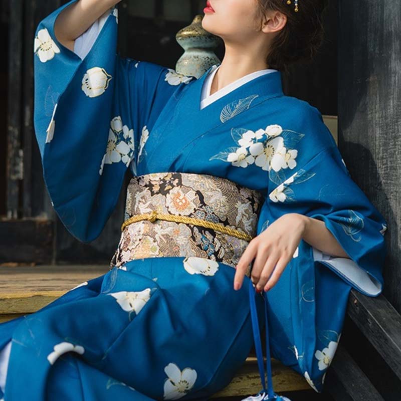 a woman is dressed with a pattern obi belt and a japanese kimono