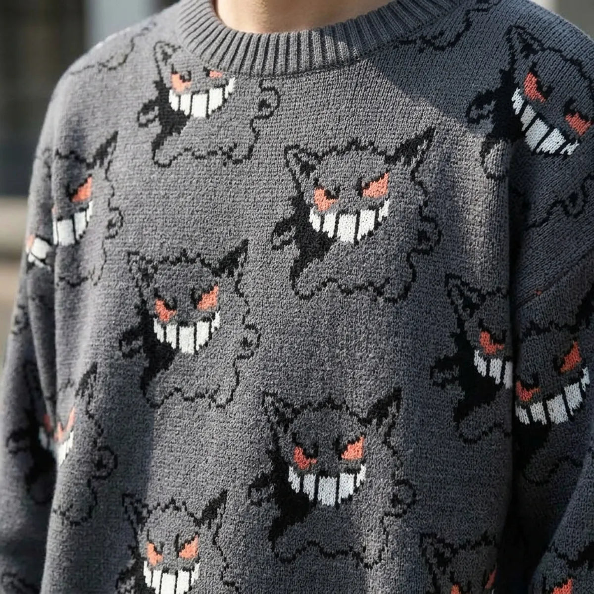 Close view of the knit jacquard showing black outline ghost faces with pink cheeks and pink tongue detail