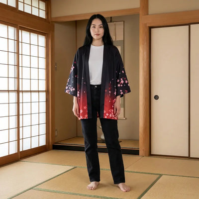 The pink sakura haori women wear open, worn barefoot on tatami, blossom rising from the red hem.