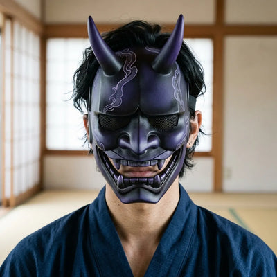 Front-facing view of the Japanese hannya demon mask in its purple-to-black ombre finish, showing the curved horns, furrowed brow and black steel mesh eye plates.