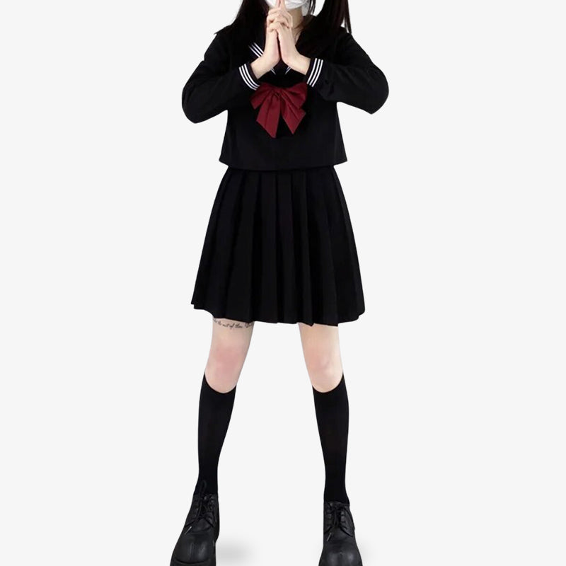 a girl standint is dressed with sailor suit japanese uniform. She wears long blackjapanese socks, a black skirt, a red ribbon and black student shirt