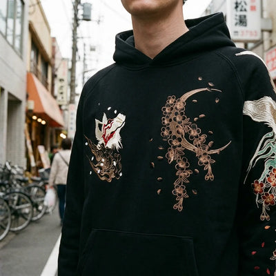 Close view of the bronze crescent moon and cherry blossoms embroidered on the chest of the hoodie