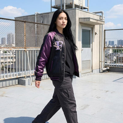 Woman wearing a souvenir jacket purple on a Japanese school rooftop with Tokyo background