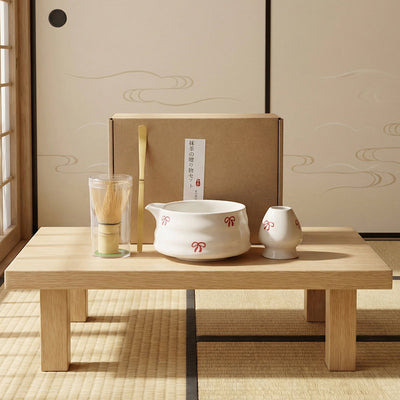 Tea-making set with a white pot and small container on a wooden table in a traditional Japanese room.
