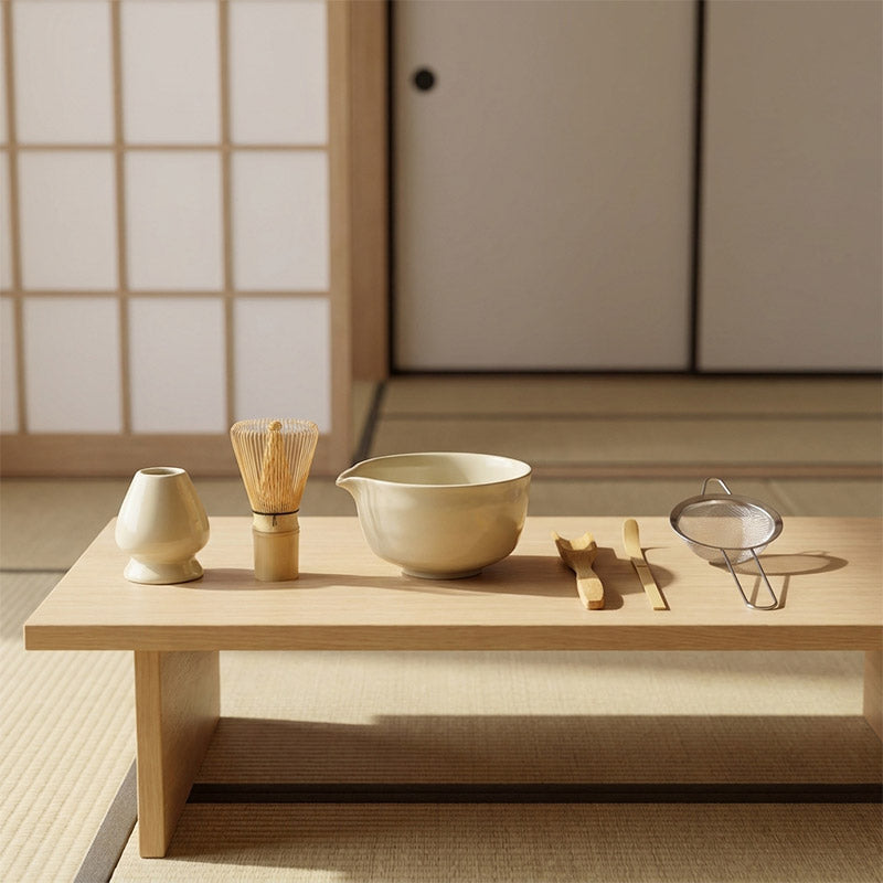 Tea-making utensils on a wooden table with a traditional Japanese room background