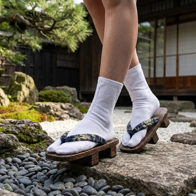 Tong Japan Geta sandal with golden dragon hanao strap in a Japanese garden