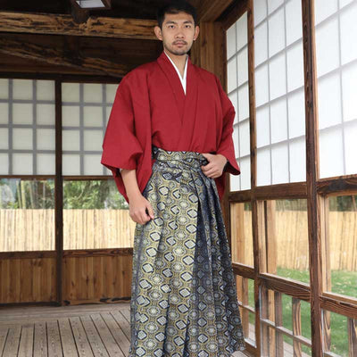 A Japanese man wearing a traditional male kimono and hakama trousers