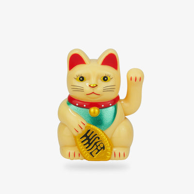The traditional maneki neko is golden in colour. Its left paw is raised to attract good luck and invite entry. It holds a Koban coin in its hand.