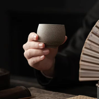 A man holds in his hand a Traditional matcha cup crafted from ceramic, perfect for enjoying Japanese matcha in a culturally authentic way