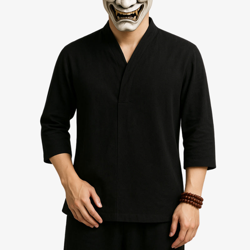 A man wearing a black v-neck Japanese shirt and 3/4 sleeves, paired with black pants and a traditional Japanese mask.