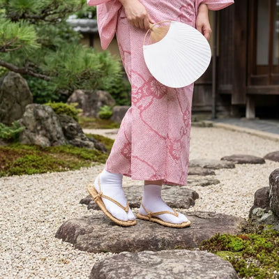 Waraji Sandals worn with a pink kimono in a Japanese garden